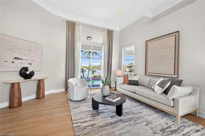 Living room featuring light wood-style flooring, crown molding, and recessed lighting