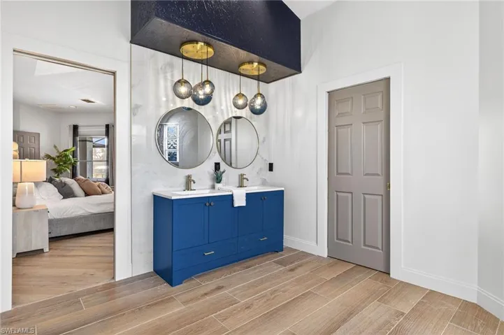 Bathroom with wood finish floors, double vanity, and ensuite bathroom