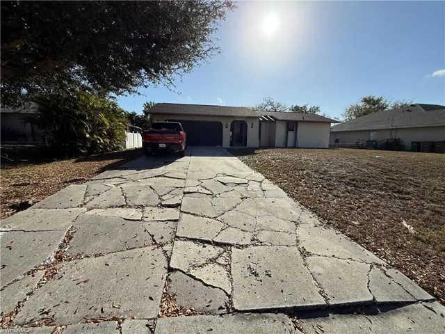 Ranch-style home featuring an attached garage, driveway, and stucco siding