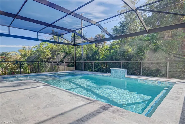 View of pool with a patio area, pool water feature, and glass enclosure