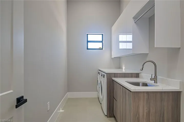 Laundry room featuring sink and washing machine and dryer