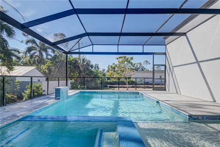 View of swimming pool with a patio and glass enclosure