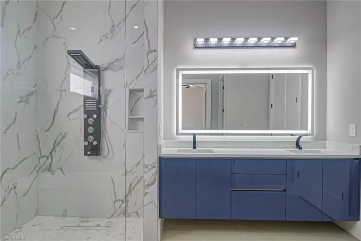 Bathroom with vanity and a tile shower