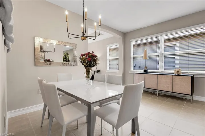 Dining room with light tile patterned floors and a chandelier