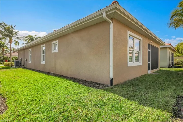 View of home's exterior featuring a lawn and stucco siding