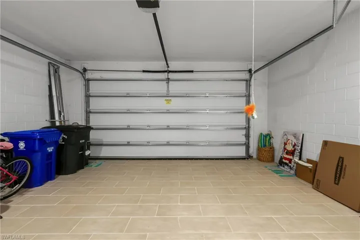 Garage featuring concrete block wall and a garage door opener