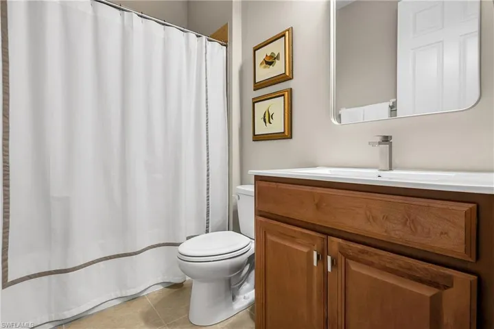 Full bathroom with vanity, a shower with shower curtain, and light tile patterned floors