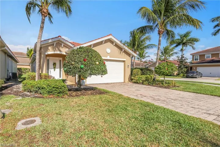 Mediterranean / spanish-style house with stucco siding, a front yard, decorative driveway, and an attached garage