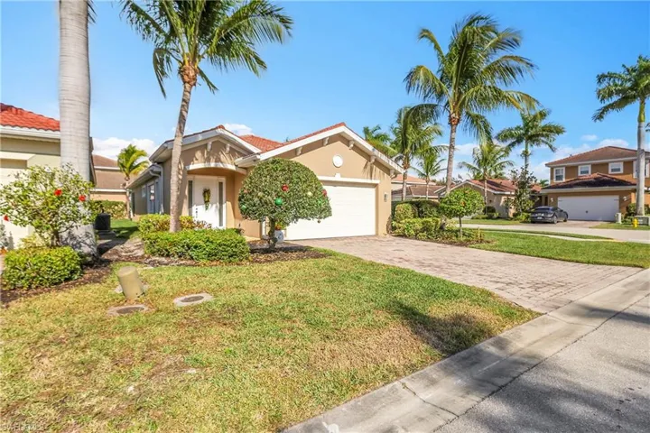 View of front facade featuring stucco siding, a front yard, decorative driveway, a garage, and a tiled roof