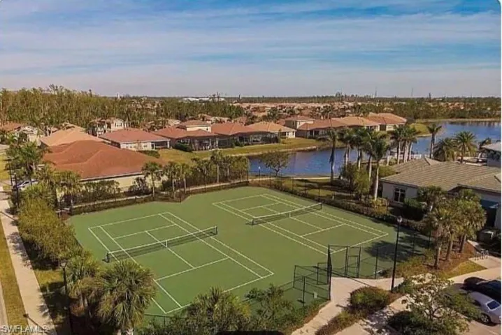 View of tennis court featuring a water view and a residential view