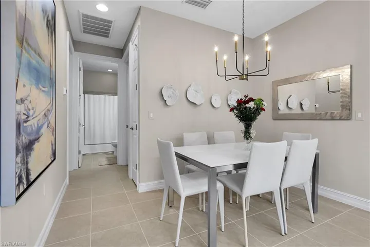 Dining area featuring light tile patterned flooring, recessed lighting, and a chandelier
