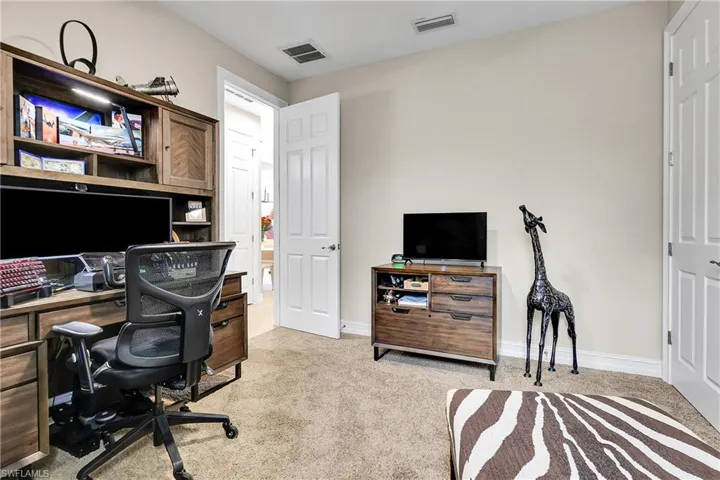 Home office with light carpet and baseboards