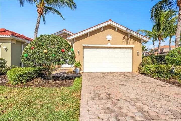 View of front of home featuring stucco siding, decorative driveway, and a garage