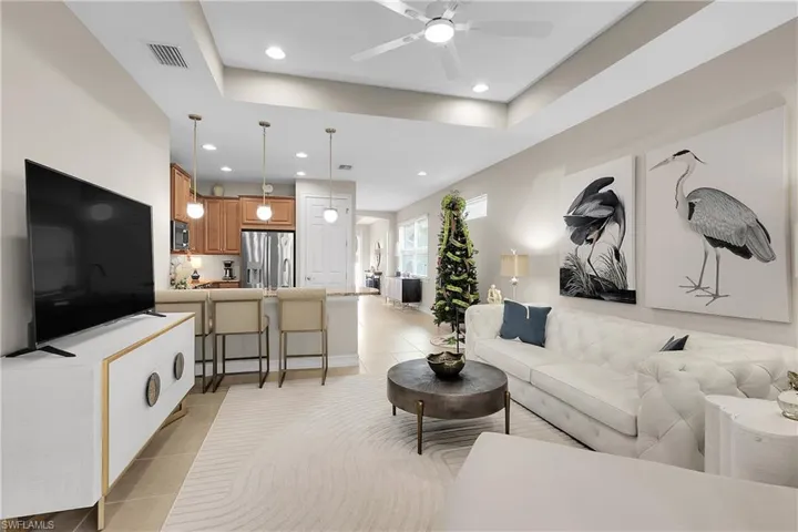 Living area featuring light tile patterned floors, ceiling fan, and recessed lighting