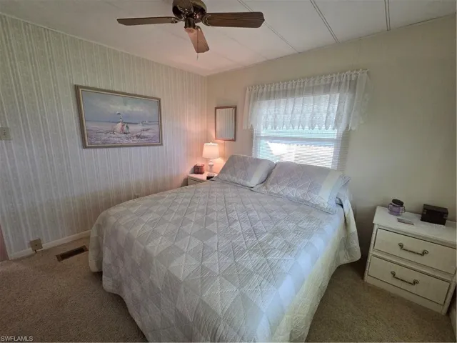 Bedroom with neutral carpet, ceiling fan, and lots of natural light.