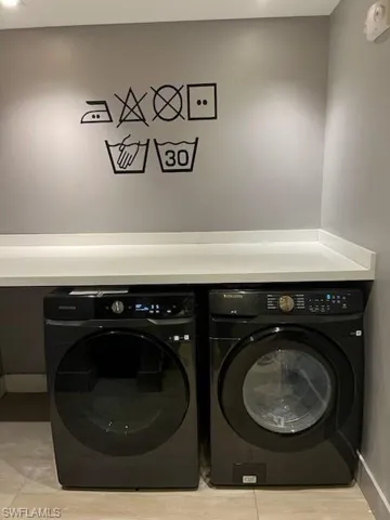 Laundry area featuring separate washer and dryer and baseboards