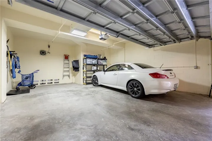 Garage featuring a garage door opener and concrete block wall