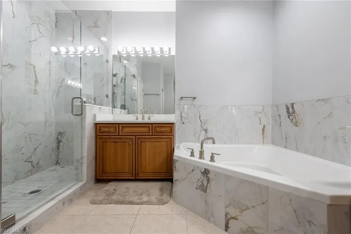 Bathroom featuring 2 vantities, tub and seperate shower