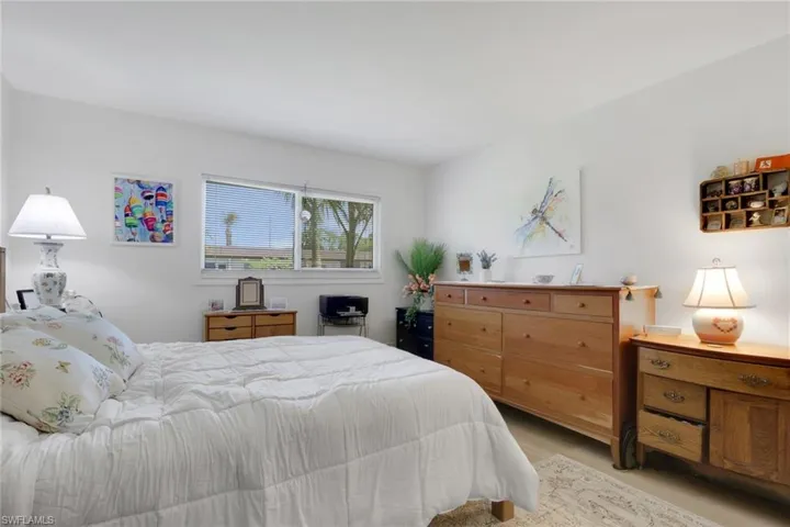 Bedroom featuring white walls, a large window, and light wood-finish flooring