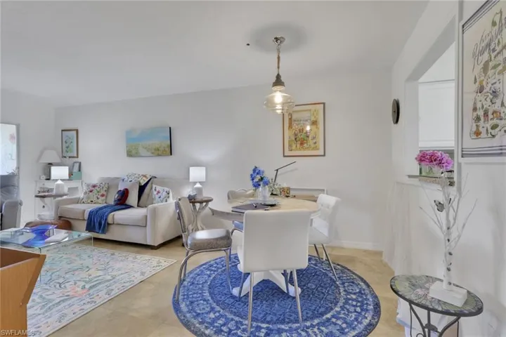 Open-concept living and dining areas featuring light-toned flooring and white walls