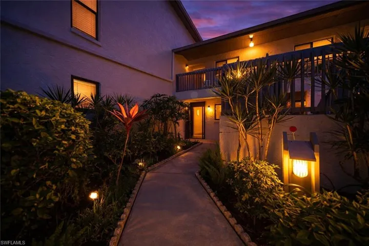 View of front of house featuring a balcony and stucco siding