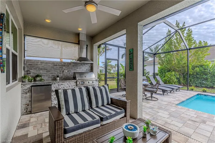 View of patio / terrace featuring glass enclosure, outdoor lounge area, an outdoor kitchen, and grilling area