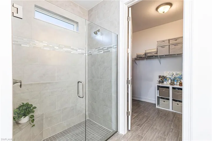 Bathroom featuring a frameless glass shower & walk in closet