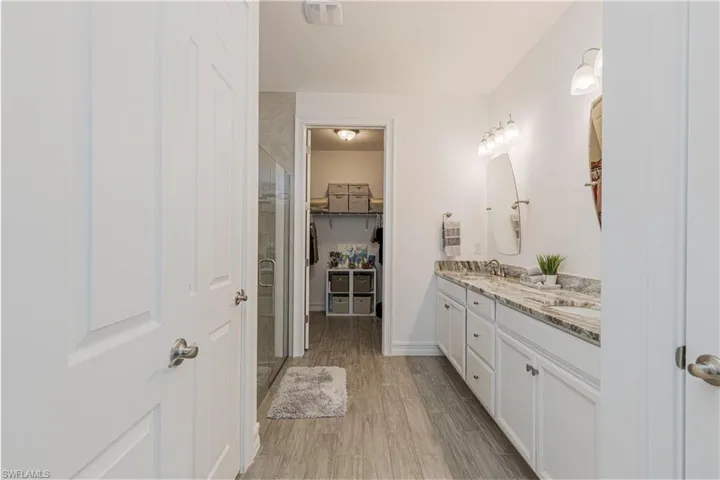 Bathroom featuring dual vanities and walk in shower