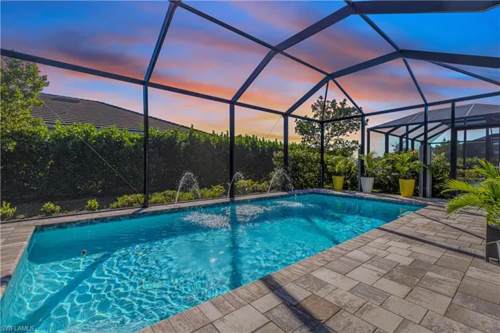 Pool at dusk with water features, and large lanai