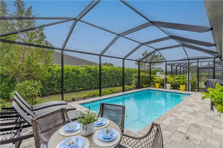 View of swimming pool with a patio and peaks of the lake