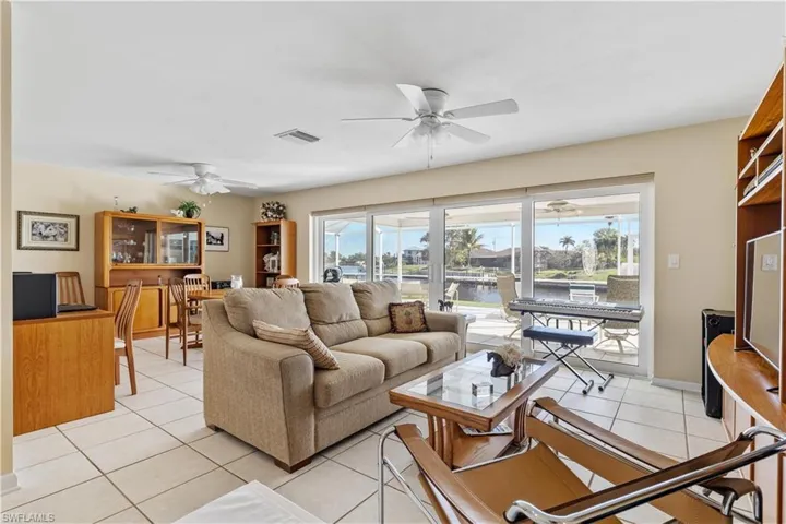 Living room with view of canal through the Impact Sliders with  dining area in the left background.