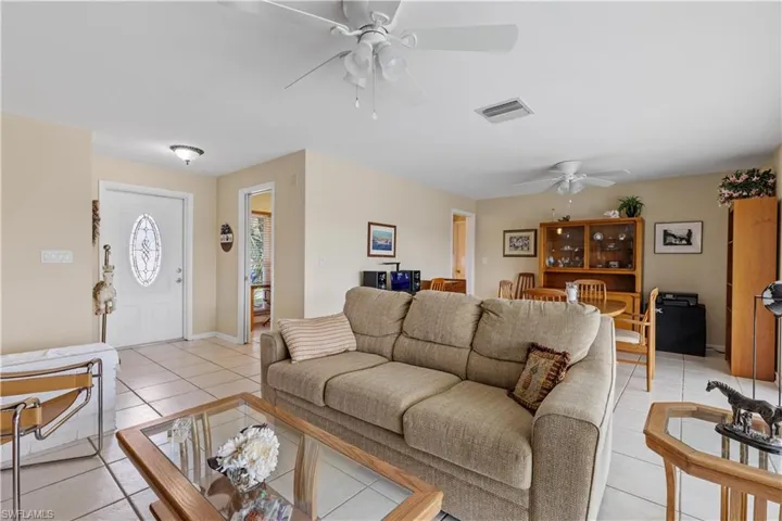 Living Room looking towards front door and entry door to kitchen. Dining Area right side background.