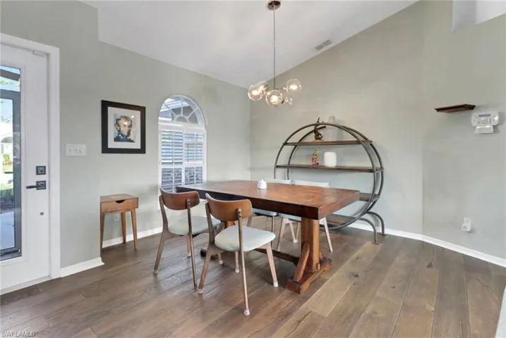 Dining area featuring lofted ceiling, a healthy amount of sunlight, and hardwood / wood-style flooring