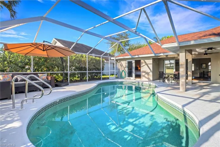 Outdoor pool featuring glass enclosure, a patio, and ceiling fan