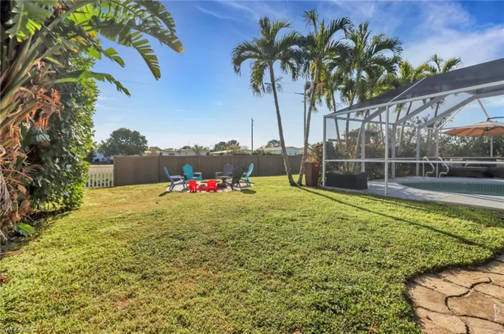 View of yard with a lanai, fence, a fenced in pool, and a patio