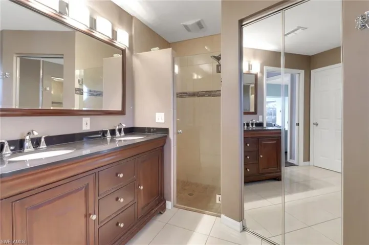 Full bathroom with a sink, a stall shower, and double vanity