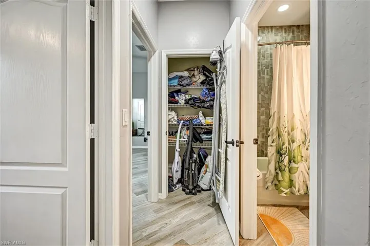 Walk in closet with light wood-type flooring