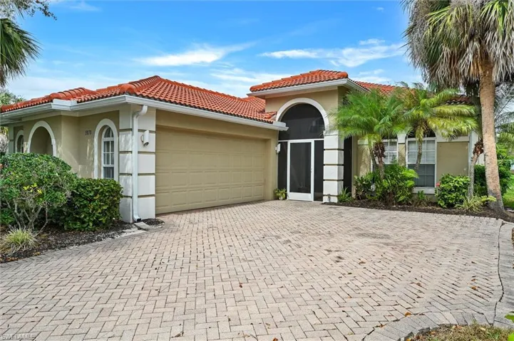 Mediterranean / spanish-style house with stucco siding, a garage, decorative driveway, and a tiled roof