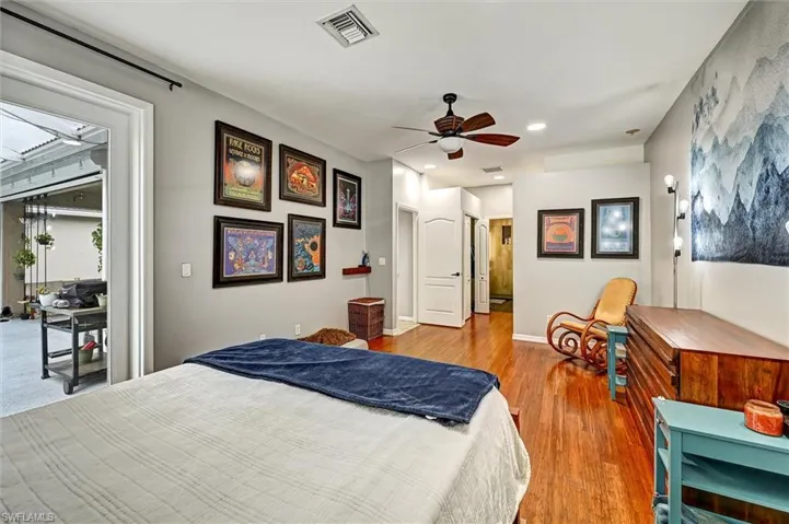 Bedroom with access to outside, wood finished floors, and a ceiling fan