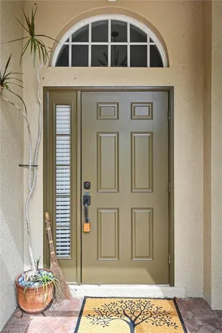 Property entrance featuring stucco siding and a patio area