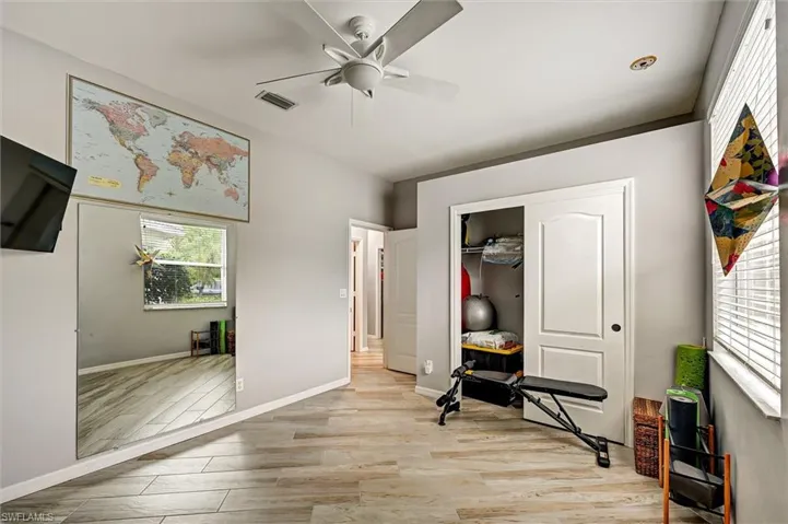 Bedroom featuring light wood-style floors, a closet, and a ceiling fan