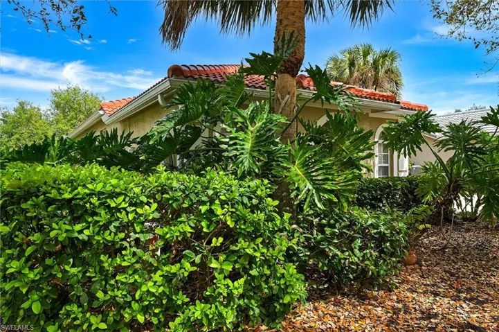 View of side of home with a tiled roof and stucco siding