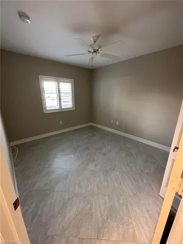 Empty room featuring a smoke detector and a ceiling fan