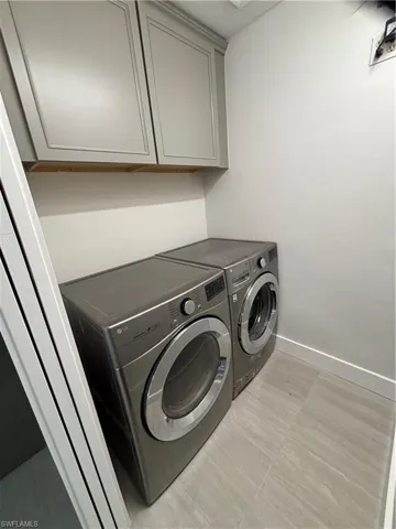 Laundry room with washer and clothes dryer and cabinet space
