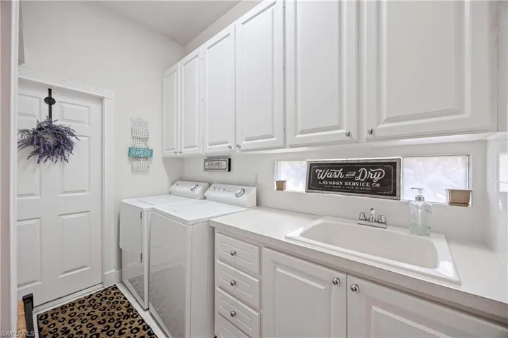 Clothes washing area featuring cabinet space and washer and dryer