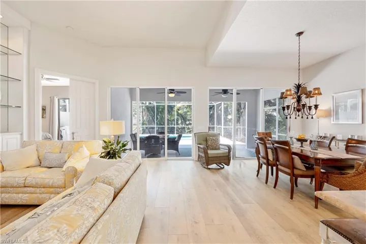 Living area with ceiling fan, light wood finished floors, and a sunroom