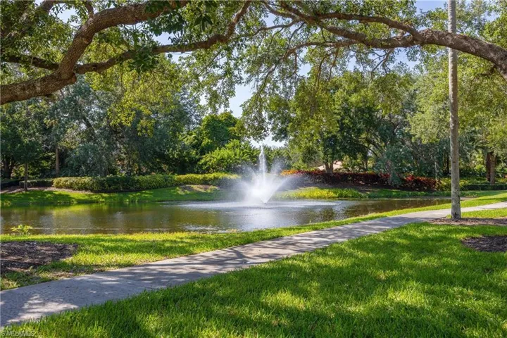 View of home's community with a water view and a yard
