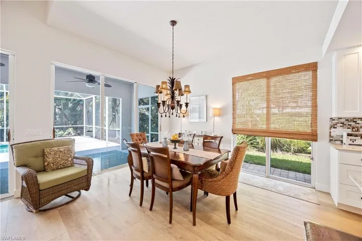 Dining space featuring light wood-style flooring, plenty of natural light, a chandelier, and ceiling fan