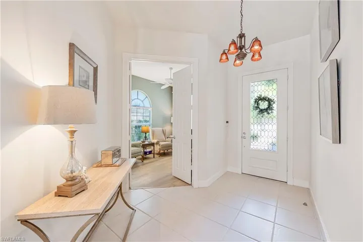 Entryway with a chandelier, baseboards, a ceiling fan, and light tile patterned flooring