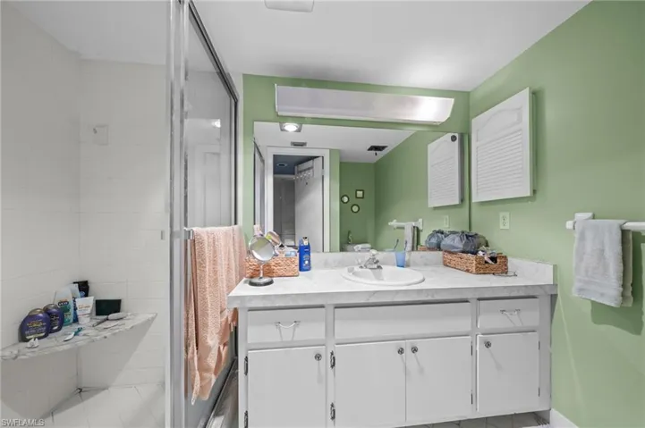 Full bathroom with vanity, a stall shower, and light tile patterned floors